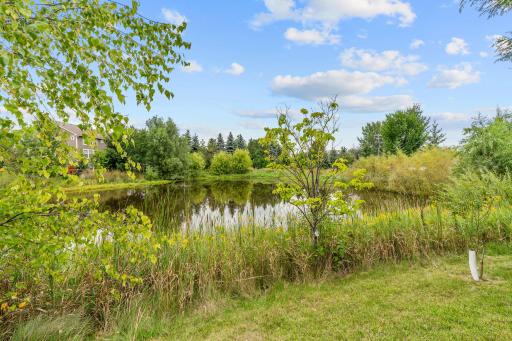 Walk out to the deck overlooking ample flat green space + beautiful pond views