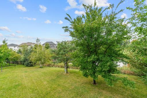 Walk out to the deck overlooking ample flat green space + beautiful pond views