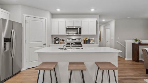 Large quartz kitchen island for entertaining. Photos are of similar staged home. Colors and options may vary. Ask Sales Agent for details.