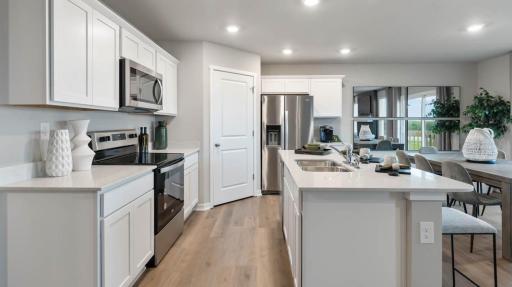 Harmony Kitchen with white cabinets, quartz countertops, and stainless steel appliances. Photos are of similar staged home. Colors and options may vary. Ask Sales Agent for details.