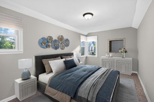 Another bright main-level bedroom with multiple windows bringing in natural light.