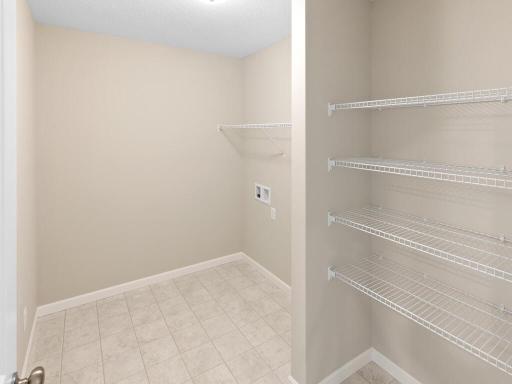 PHOTO OF A DIFFERENT HOME WITH SIMILAR PLAN & FINISHES. Plan and finishes may vary. Upper Floor Spacious Laundry Room.