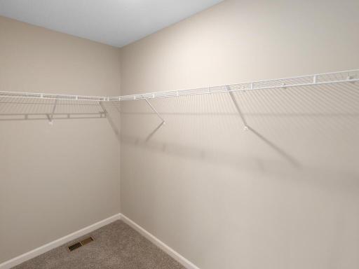 PHOTO OF A DIFFERENT HOME WITH SIMILAR PLAN & FINISHES. Plan and finishes may vary. Primary Suite Walk-in Closet.