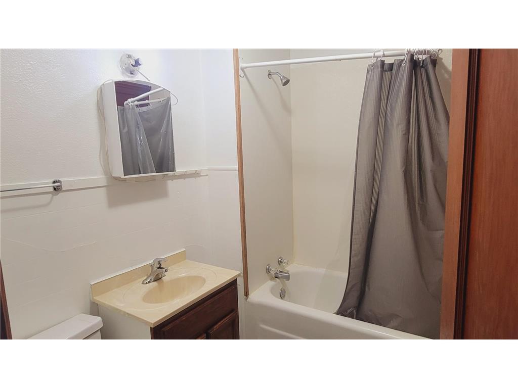Full Bath Featuring Easy-Care Tub Surround and Wood Vanity