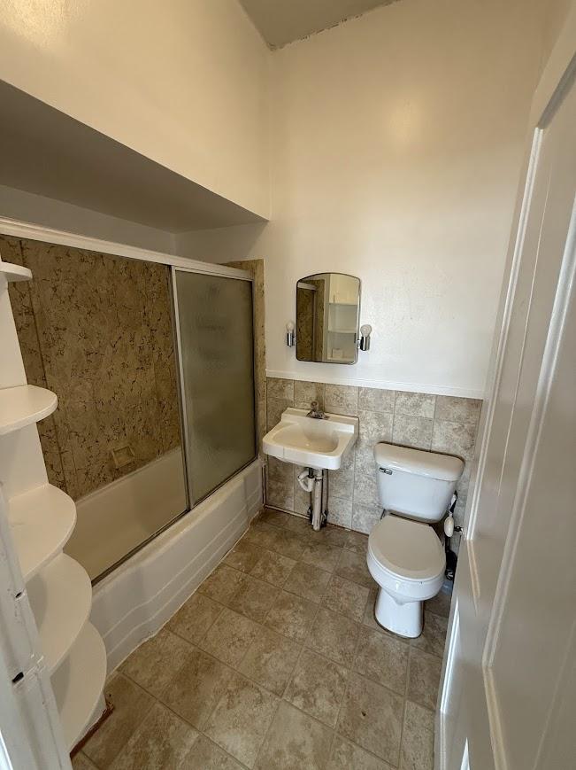 Unit 5: Full Bathroom Featuring Tub/Shower Combo with Sliding Glass Doors