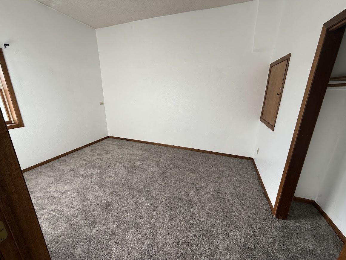 Unit 5: Carpeted Bedroom with Natural Light and Wood Trim Accents