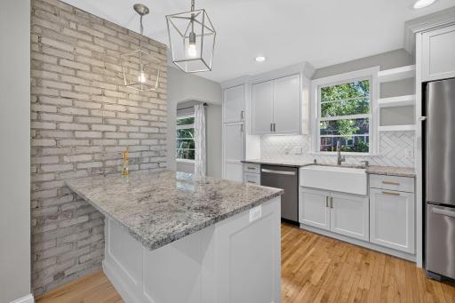Large center island and farmhouse sink complement the beautifully updated kitchen.