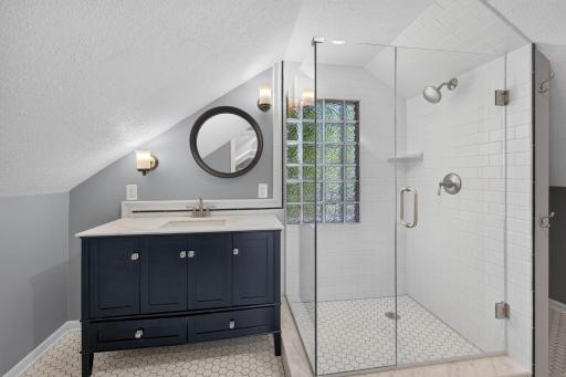 Private upper-level primary suite features a beautifully updated three-quarter bath.