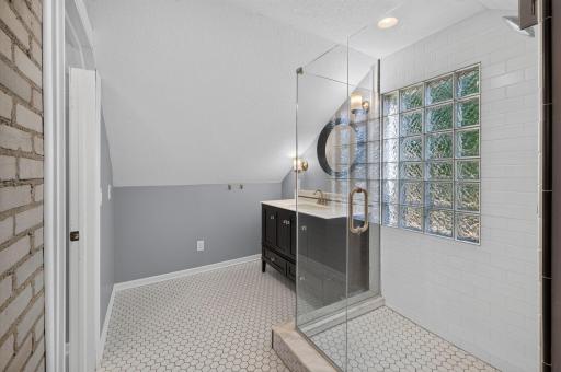 Glass-enclosed shower and glass block wall add style and natural light.