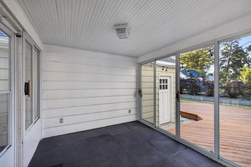 Enclosed porch provides a welcoming transition to the backyard and deck.