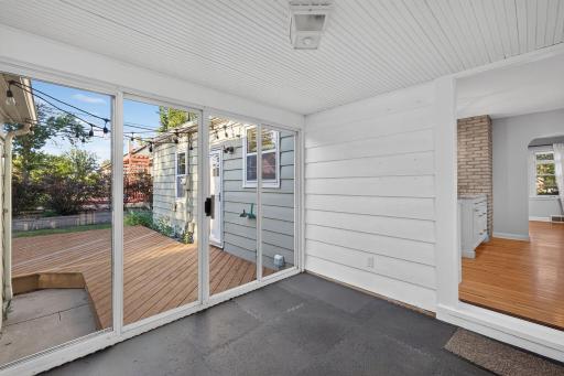 Bright enclosed porch opens directly to the spacious backyard deck.