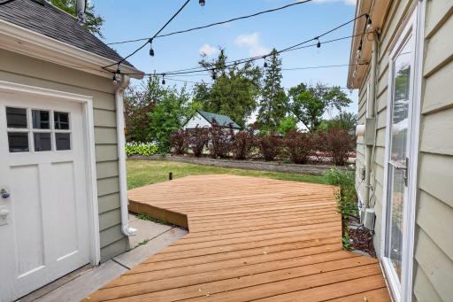 Spacious deck with string lights creates an inviting outdoor entertaining space.