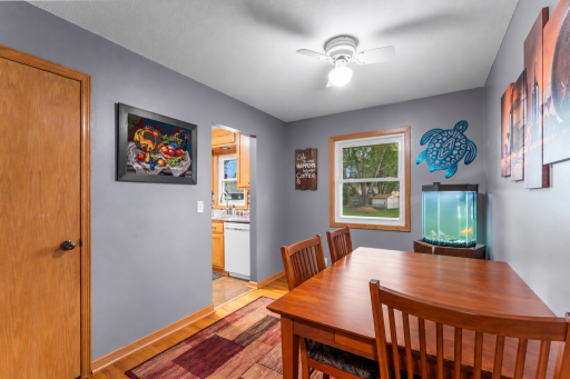 : A welcoming dining space just off the kitchen, with hardwood flooring and a large window bringing in natural light