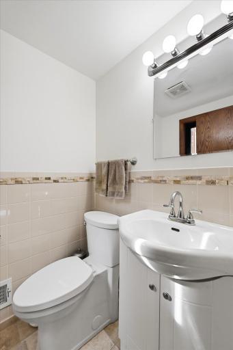 Located just off the family room, the updated half bath features modern fixtures and easy access for guests.