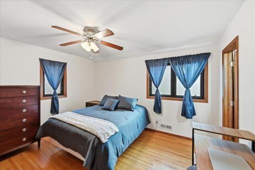 Designed as the home's original primary suite, this inviting bedroom features a private 3/4 bath, beautiful hardwood flooring, Anderson windows, and a thoughtfully designed closet organizer for efficient storage.