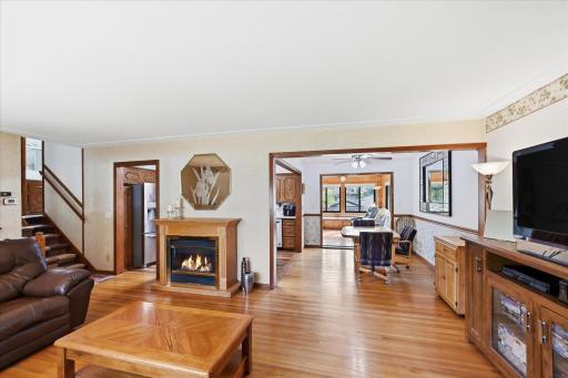 Rich oak hardwood floors extend throughout the upper two levels, creating a warm and inviting atmosphere. The generously sized dining room easily accommodates large gatherings and flows effortlessly to the kitchen, living room, and four-season porch.