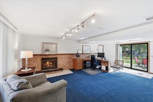 The expansive family room features abundant natural light, newer carpeting, and a cozy wood-burning fireplace. With space for a sectional and television, this inviting room also leads to the outdoor patio and access to the garage.