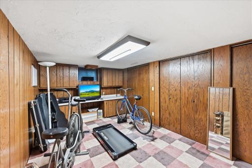 A versatile lower-level space currently serves as a home gym but could easily be transformed into a fourth bedroom with the installation of an egress window. Built-ins, ample closet space, and exceptional storage make this room flexible space.