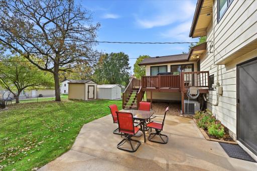 Closer view of the impressive outdoor living spaces, including a large patio, deck off the four-season porch, and two storage sheds.