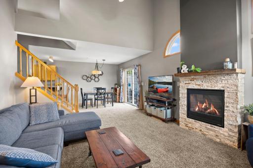 The carpeted living area flows seamlessly into the dining room, featuring sliding glass doors that showcase the inviting patio beyond.