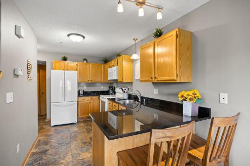 The kitchen offers tiled floors, updated appliances and gleaming countertops with a breakfast bar.