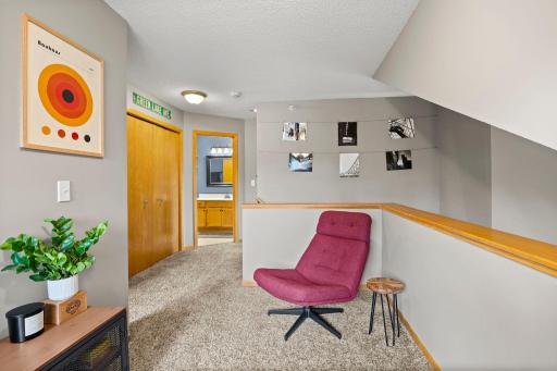 Upper level lounging area off the staircase, hallway also features large closet for extra storage.