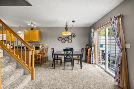 View of the open kitchen and dining area that also showcases the sliding glass doors leading outside.