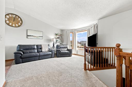 Living Room with updated flooring, vaulted ceilings and bay windows.