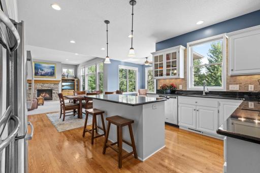 Beautifully appointed kitchen features professional white enamel cabinetry and black granite countertops.