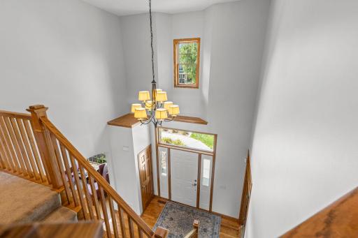 Sparkling chandelier and classic mission-style oak railings highlight the dramatic two-story foyer.
