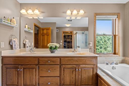 Private primary bath features a large dual-sink vanity with excellent storage.
Spacious soaking tub creates a relaxing retreat within the primary bath.
