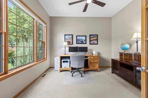 Triple-pane picture windows fill the home office with natural light.