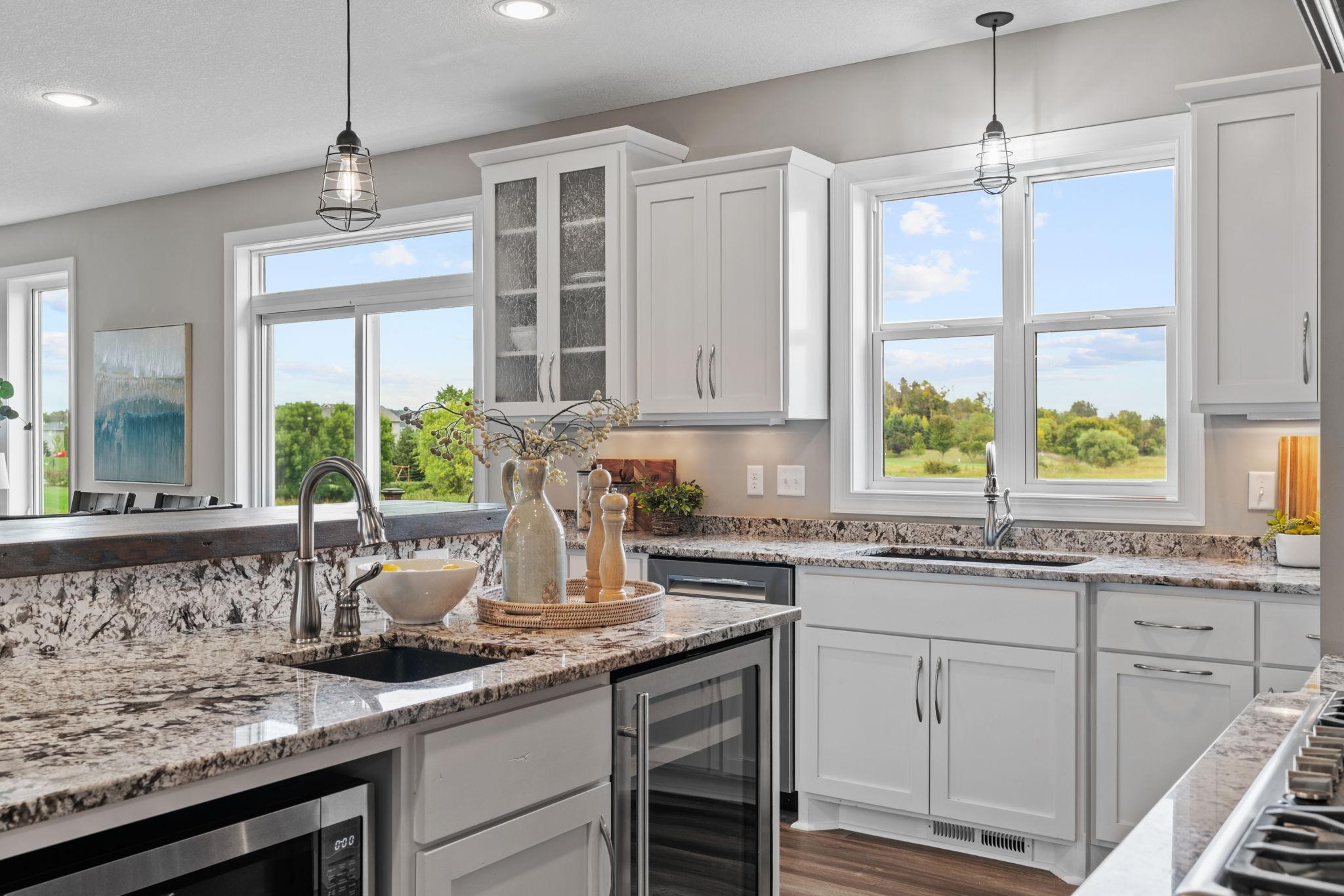 Gourmet Kitchen w/ granite + butcher-block counters, white cabinetry, subway tile backsplash, SS apps incl Thermador gas cooktop + double ovens, hood, beverage fridge + pantry