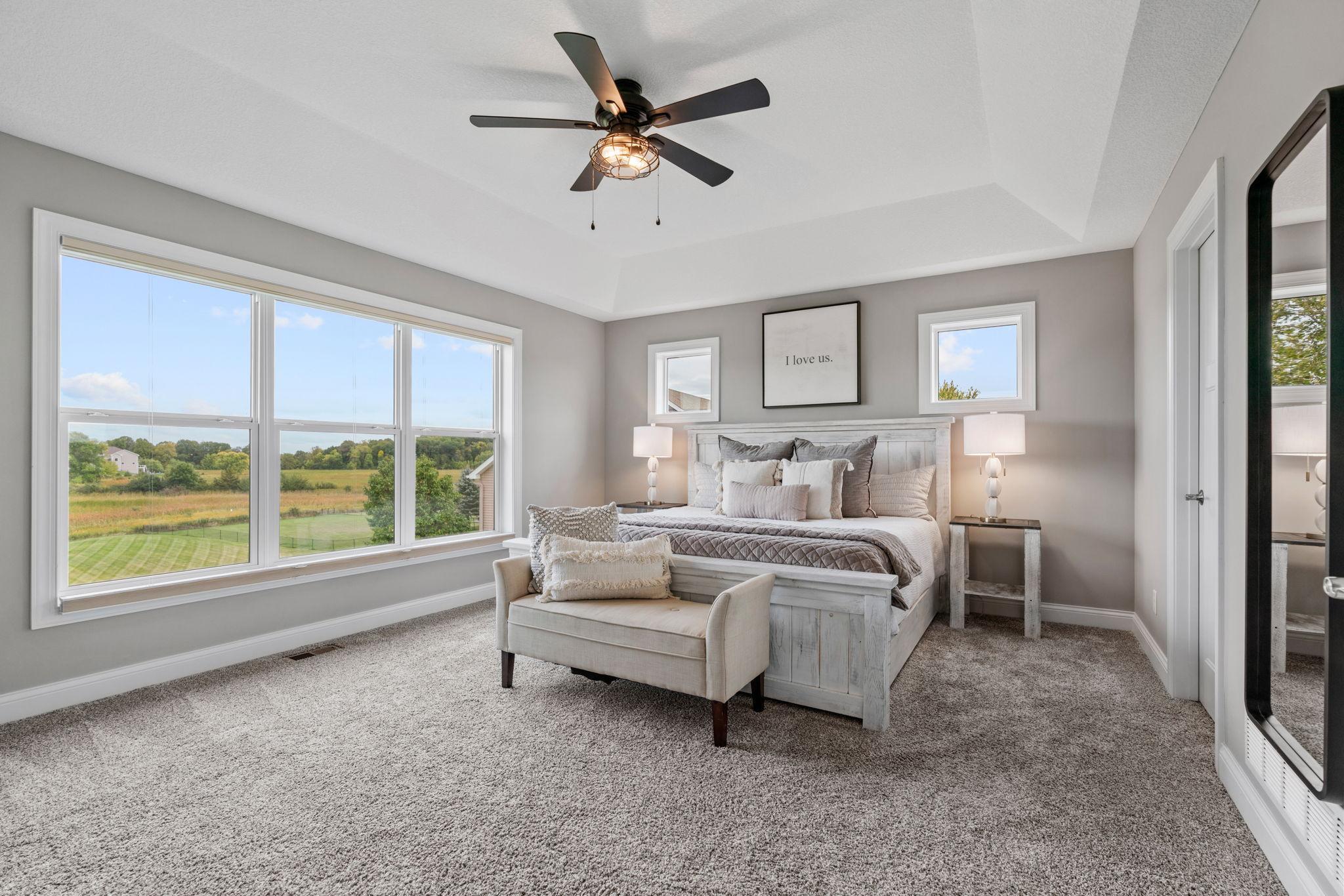 Vaulted Primary Suite w/ ensuite bath featuring dual sinks, separate tub/shower + WIC.
