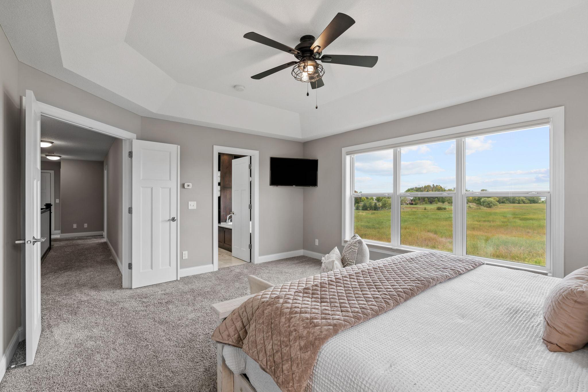 Vaulted Primary Suite w/ ensuite bath featuring dual sinks, separate tub/shower + WIC.