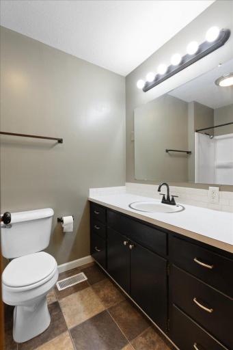 Main-level full bathroom offers a long vanity with ample counter space and storage.