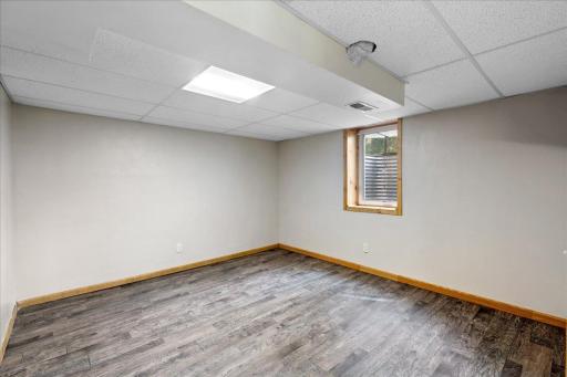 One of two lower-level bedrooms features durable flooring and an egress window for natural light.