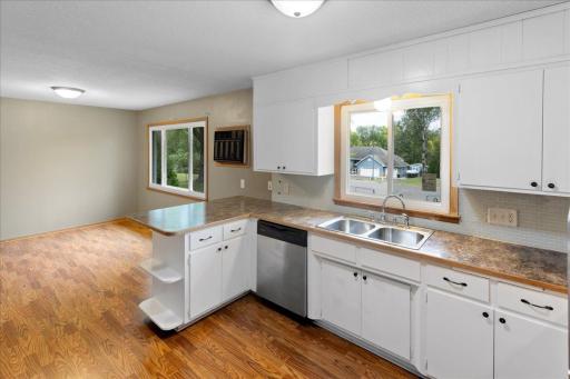 Another view of the kitchen highlights the convenient peninsula, dishwasher, and adjoining dining area.