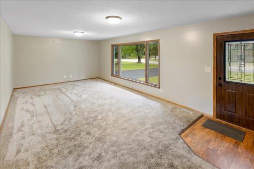 Main-level living room features a spacious layout with a large picture window overlooking the front yard.