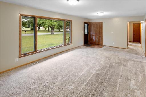 View of the bright main-level living room, filled with natural light from the oversized front window.