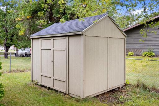 Additional storage shed provides convenient space for lawn equipment, bikes, and outdoor essentials.