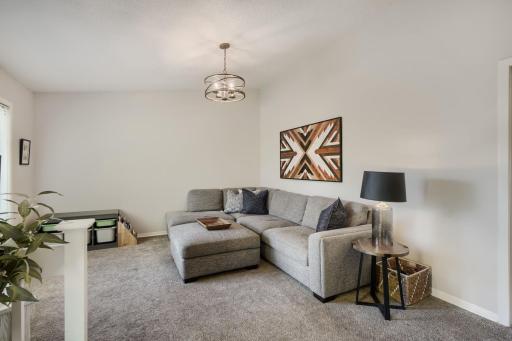 The Living Room with neutral grey wall and grey carpeting. Just Move In!