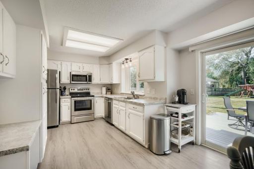 The Kitchen has white cabinets and stainless steel appliances. Patio doors lead to LARGE backyard that is fenced. The Deck is maintenance free too!