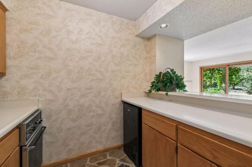 Kitchenette with stove, wet bar and new refrigerator is adjacent to family room.