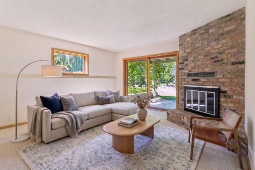 Virtually staged, this lower level family room has a wood-burning fireplace and a walk-out patio.