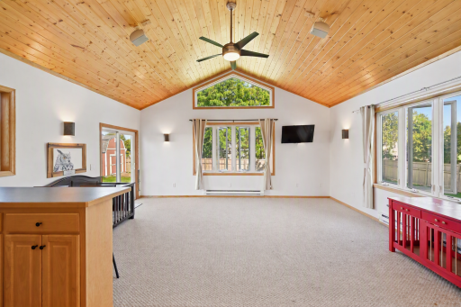 Stunning porch with vaulted wood ceiling, wet bar, and tranquil backyard views.