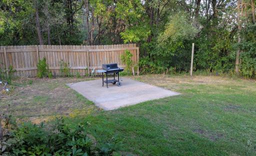 East side of home has a covered patio and a concrete slab for summer barbecues.sla