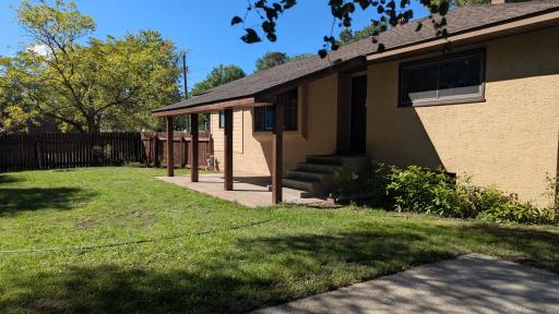 Covered Patio overlooking a flat green space, perfect for an above ground pool, swing sets, badminton, and a variety of outdoor activities.