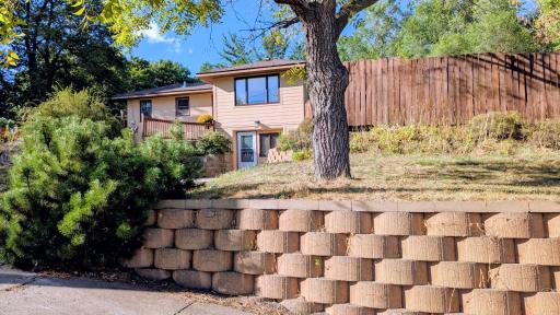 Beautiful retaining wall in front of privacy fence leading to a flat yard with the covered patio.Side flat yard is partially fenced
