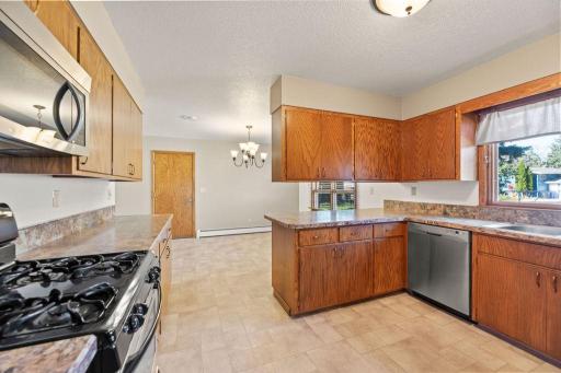 Kitchen features lots of cabinets, stainless appliances, breakfast bar peninsula.